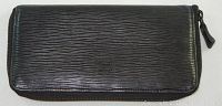 Front view of black textured leather wallet showing full zipper and embossed Givenchy logo on front.