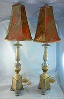 Pair of tall table lamps with decorative metal bases and patterned fabric shades shown against a plain background.
