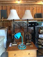 Two tall table lamps with fabric shades and glass pendants visible, placed on a wooden surface.