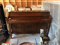 Full view of Jonas Chickering upright piano, showing solid wood construction and front panel, top closed.