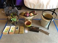Full overview of lot with faux fruit, planters, wall plaques, pen box, and sticks.
