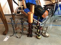 Full view of all candle sticks including silver hammered tulip pair, orange glass trio with candles, and painted wooden candle sticks