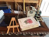 Wide shot showing nautical tissue box and soap dispenser on a glass top table with several stands and floral wall hangings arranged around