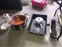 Full view of all kitchen items including mixing bowls, roasting pan, kettle, strainer, measuring cup, and electric wine opener on charging base.