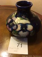 Front view of vase showing overall bulbous shape and hand-painted pansy design