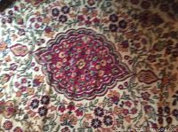 Close-up of the central area of the rug showing floral medallion pattern and stains.