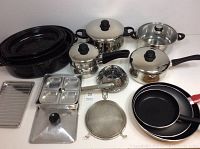 Photo showing the full assortment of cookware items including pots, pans, roasting pan, tray, and kitchen tools.