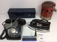 Full lot view including rotary dial telephone, General Electric iron, red heater, blue metal box, and box of disinfectant tissues