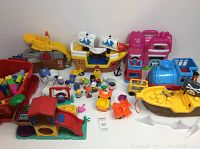 Full lot displaying various Fisher-Price toys including pirate ship, train, slide, and figures plus loose Mega Bloks.