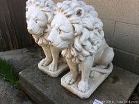 Front-left perspective of both lion statues on concrete slab