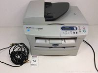 Full front view of Brother DCP 7020 laser copier printer scanner with power and ethernet cables visible.