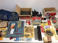 Full lot overview showing socket set, clamps, box of spiral nails, padlock, and various small hardware packs