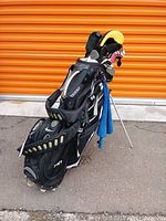 Full set of clubs assembled in Nike stand bag outdoors against orange door.