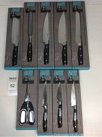 Top-down view of five long-handled knives and honing steel in packaging