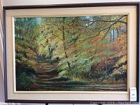 Framed oil painting of a wooded landscape with a path