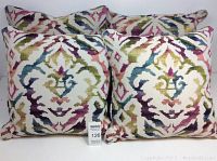 Four matching throw pillows arranged upright showing colorful abstract pattern, front view.