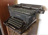 Angled view showing entire vintage Underwood typewriter with black metal body and round keys.