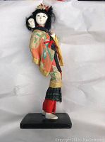 Front side profile view showing detailed face of mother and child, traditional clothing patterns, and base.