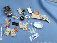 Overview of all miniature dollhouse items laid out on blue cloth background