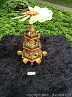 Full view of the entire German Christmas pyramid, showing three tiers, painted figurines, four candle holders around the base, and the large wooden fan on top