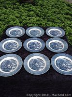 Nine identical blue and white ironstone plates arranged in three rows of three, showing the detailed winter scene design.