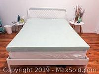 Memory foam mattress topper fully spread out on a bed showing size and color.