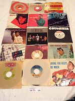 Photo showing assortment of 45 RPM vinyl records with original sleeves, featuring artists such as The Doors, Prince and the Revolution, Harry Belafonte, Pablo Cruise, Fleetwood Mac, and others.