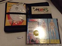 Paint set includes watercolor pad and 12 tubes of paint in a black case, along with a paint mixing palette.
