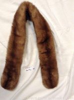 Full view of the vintage mink fur stole laid flat on a white background showing its shape and length.