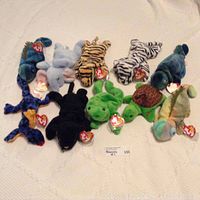 Photo of ten different Ty Beanie Babies arranged on a white surface showing tags attached
