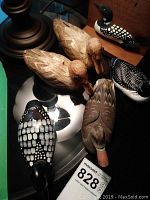 Overview of all waterfowl figurines including wooden corn husk ducks, ceramic duck, and loon ceramic and wooden pieces