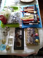 Overview of assorted candles, candle holders and companions on table: includes tapers, votives, pillars, spiral candles and silver colored holders