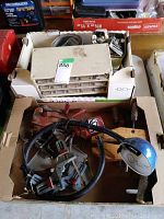 Assorted hardware including screws, nuts, bolts in a white multi-drawer organizer, steel clamps with red handles, a hand-powered grinder with blue housing and black cord in a cardboard box.