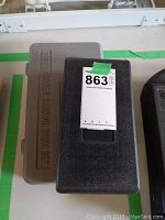 Photo of a closed beige plastic case labeled 'Rubber Sanding Drum Set' with a smaller black case beside it representing the tool kit.