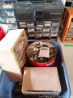 Photo showing the Mastercraft metal caddy with multiple small drawers, wooden drawer organizer, red metal container with clips, and cardboard box containing nails