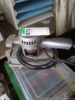 Gray Black & Decker Industrial electric sander with label showing brand and product line, coiled cord visible.