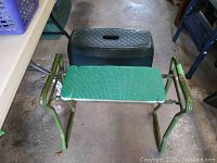 Garden seat folding frame with green woven seat and foam padding, placed in front of plastic garden step