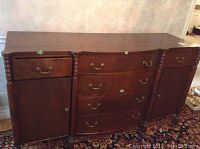 Front view of whole vintage wood server showing three central drawers and two side cabinets with metal handles and carved legs.