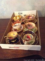 Six tea cup and saucer sets arranged in a MaxSold box