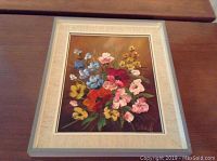Framed floral oil painting on board showing colorful bouquet on brown background.