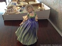 Front view of Royal Doulton Jane figurine in flowing dress with bonnet and shawl.