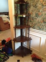 Full view of the five-tier wooden corner stand showing its structure and placement in a room corner.