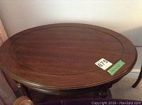 Top view of the oval wooden table showing the wood grain and decorative inlay line near the edge.
