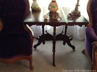 Front view showing the table top and front carved apron with turned legs and items on top (not included).