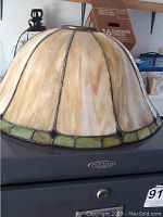 Front view of dome-shaped Tiffany style lamp shade in beige and green stained glass