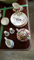 Top view of Paragon covered sugar bowl, creamer, Royal Worcester Petra cream and sugar, England salt and pepper shakers, and eight floral saucers.