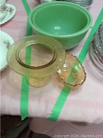 Overview photo showing two green Fire King bowls and two amber Depression glass bowls on a pink tablecloth with green tape.