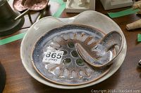 Top view of MCM art glass bowl showing speckled finish and sculptural handle, with lot number sticker visible.