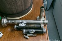 Four vintage Eveready flashlights in chrome and black with ribbed design, and a small metallic screw tool case on a wooden surface.