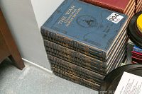 Stack of blue cloth-bound volumes with gilt spines.